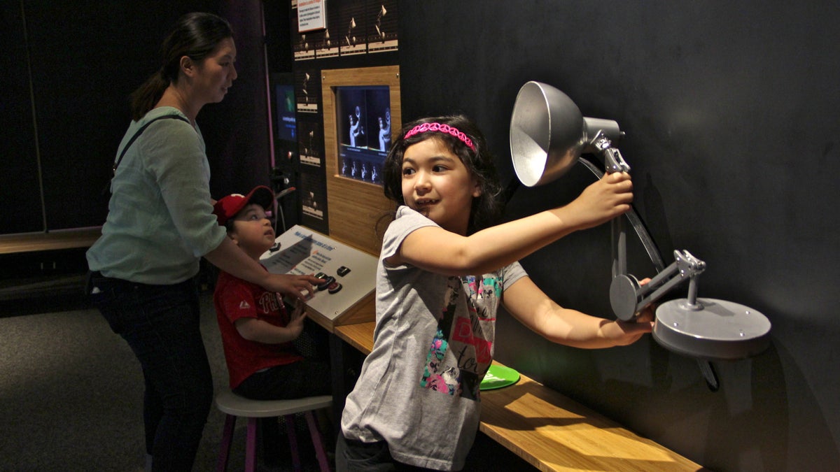 Sophia Vertlieb, 8, and her brother, Alex, 3, create a stop-action animation at the Franklin Institute's new exhibit, The Science Behind Pixar. (Emma Lee/WHYY)