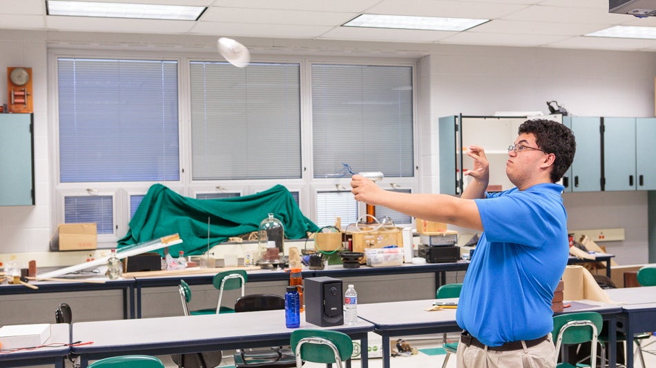 Physics team member Andrew Mangabat practices the 'Magnus Glider' challenge for IYPT 2015. (Jack Dugan/WHYY)
