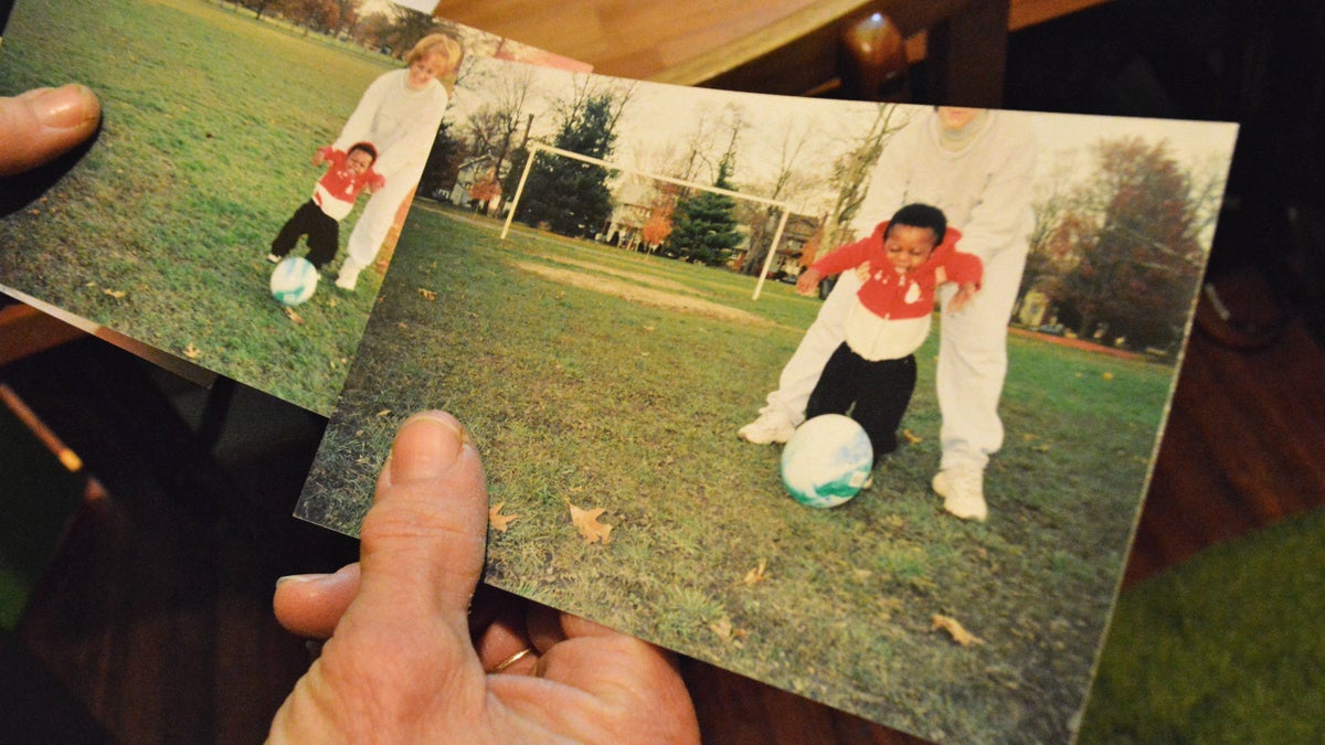 Mary Anne Degenhart holds pictures of her and her son Joseph playing in the park. The photos were taken on the day that they brought Joseph home from the hospital. (Paige Pfleger/WHYY)