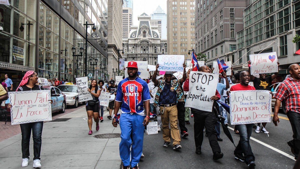 Members of the Philadelphian Haitian community march down Market Street Thursday afternoon chanting ‘boycott the D.R.!’ (Kimberly Paynter/WHYY)