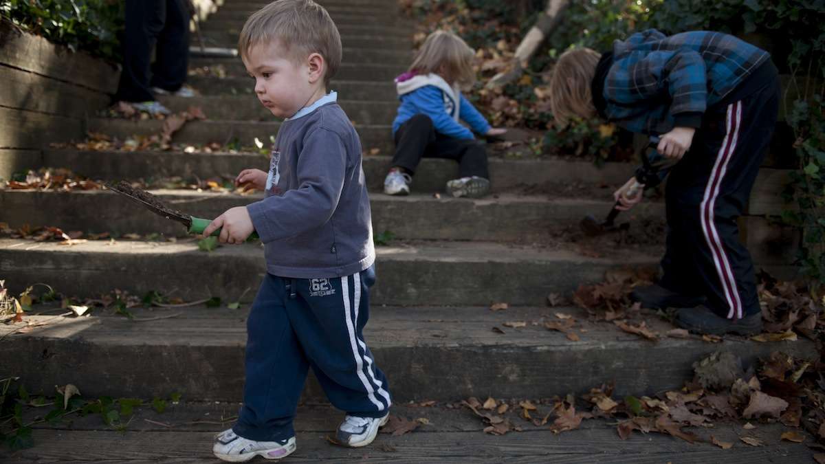  Isaiah Hoke, 2, of Germantown, helps clear dirt from the steps to Fernhill Park on Love Your Park Day. (Tracie Van Auken/for NewsWorks, file) 