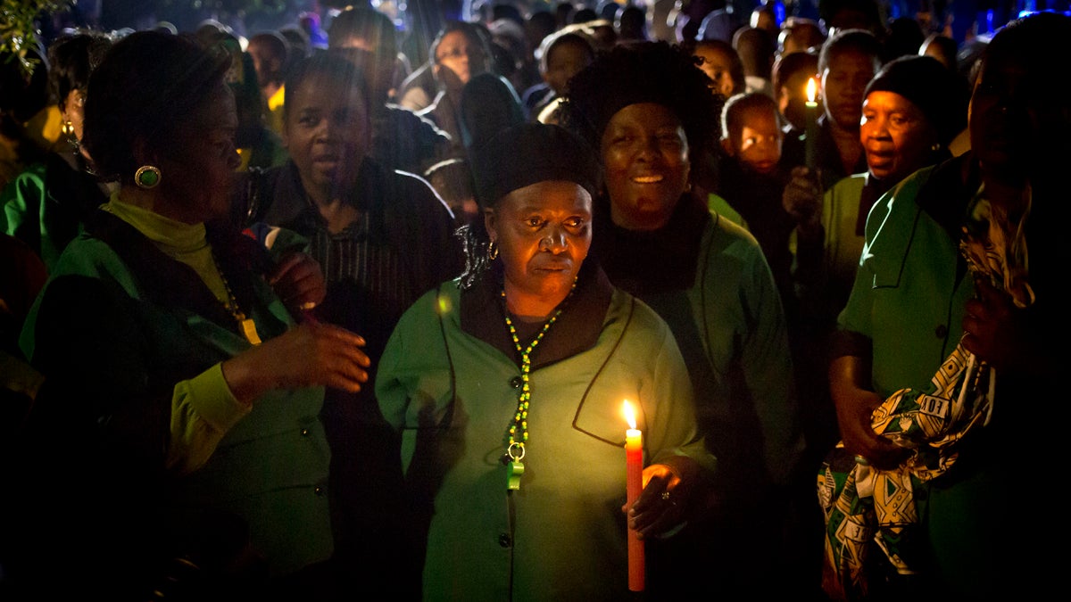  Members of the African National Congress Womens League hold candles and sings songs in memory of Nelson Mandela outside his old house in Soweto, Johannesburg, South Africa on Friday. (AP Photo/Ben Curtis) 