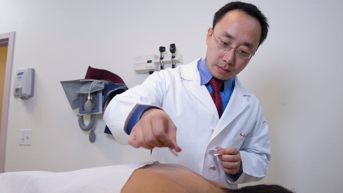 Dr. Jun Mao, a specialist in alternative therapies in oncology, prepares a patient for an acupuncture session. (Photo courtesy of University of Pennsylvania) 