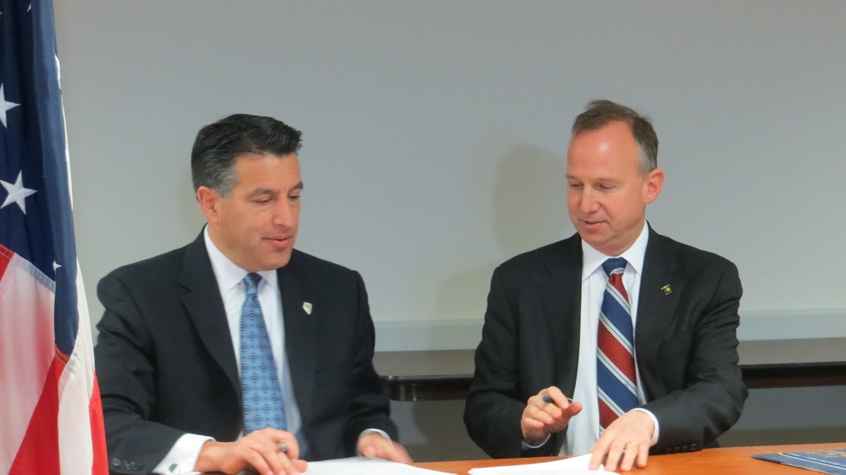  Gov. Brian Sandoval (R-Nevada) and Gov. Jack Markell (D-Delaware) sign the Internet gaming agreement in Wilmington. (Shana O'Malley/for NewsWorks) 