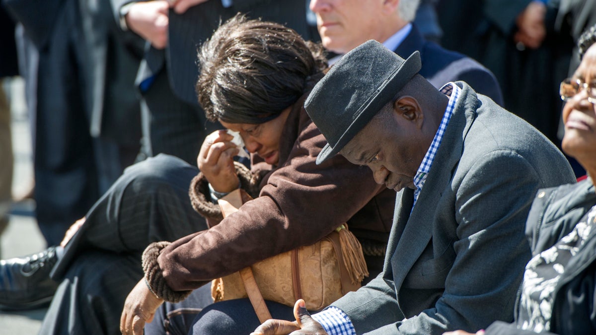 Building collapse victim Roseline Conteh's sister, Kadie Conteh, and husband, Aiah Boya, listen to speakers during the groundbreaking. (Jonathan Wilson for NewsWorks)