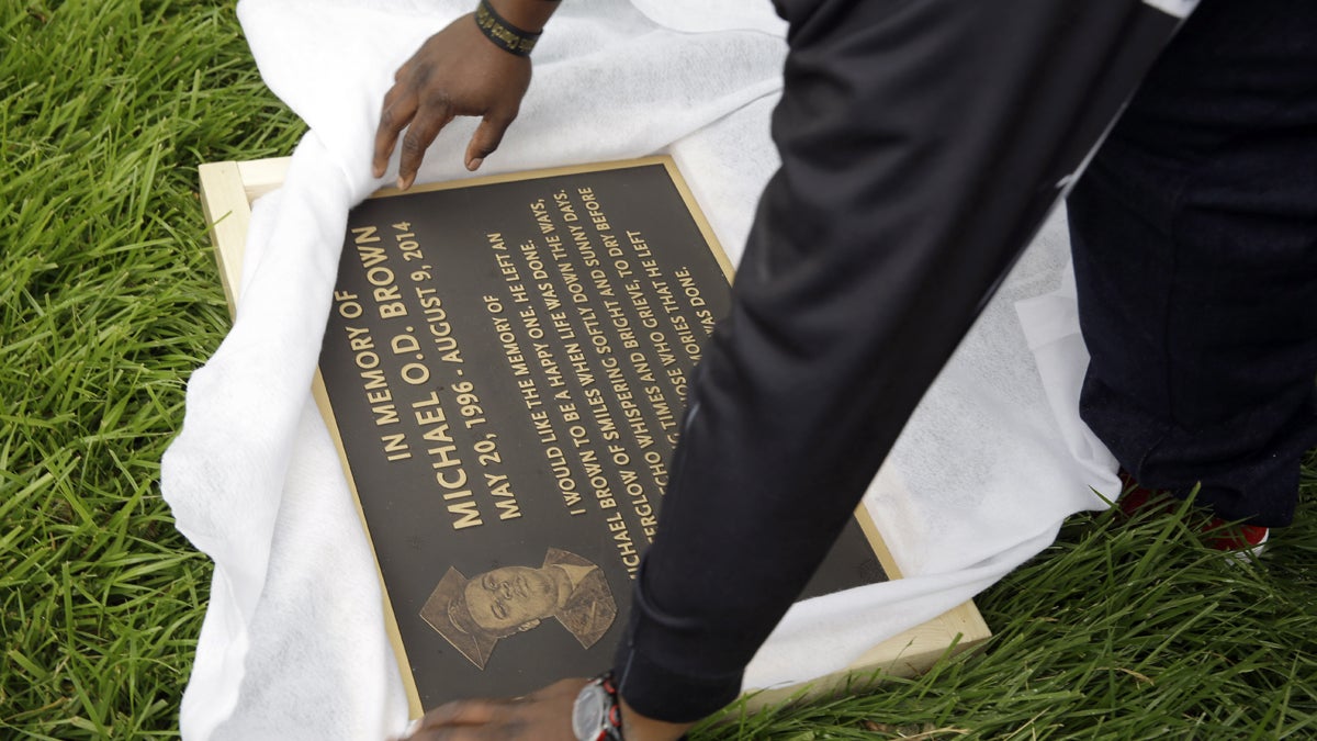  Michael Brown Sr. is shown unwrapping a plaque memorializing his son, Michael Brown in Ferguson, Missouri. (AP Photo/Jeff Roberson, file) 