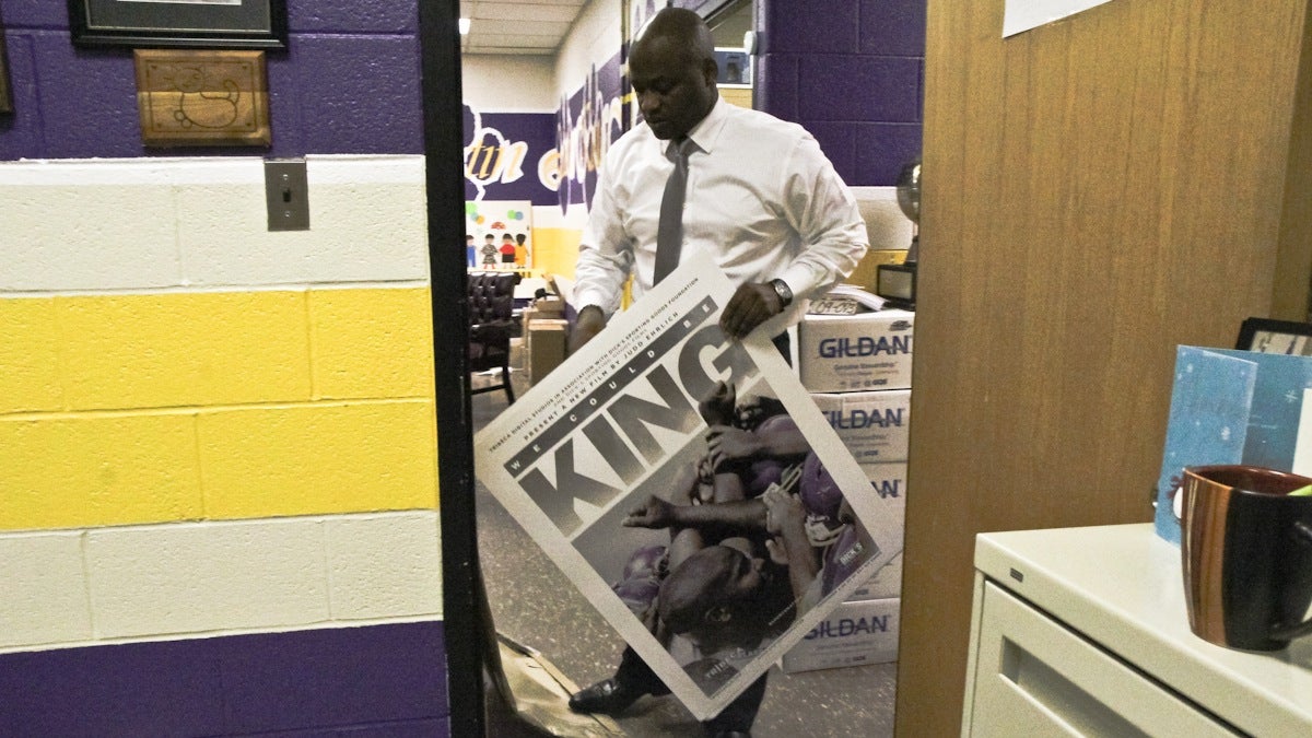  Martin Luther King High principal William Wade hands 'We Could Be King' posters around MLK's campus. (Kimberly Paynter/WHYY) 