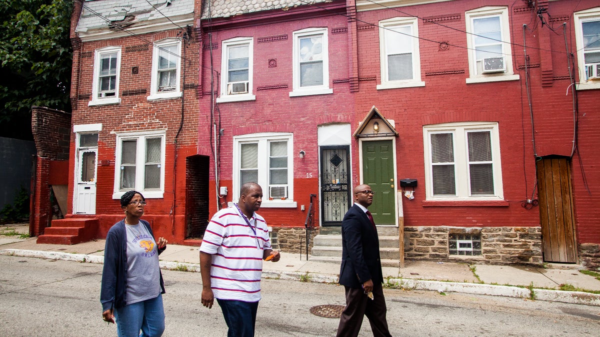 Principal WIlliam Wade, right, Conflict Resolution Specialist's Thomas Stubbs and Deborah Folk of Martin Luther King High School search for the home of an incoming freshman. Out of service phone numbers and old addresses have been a source of frustration in trying to reach out to new students. (Brad Larrison/for NewsWorks)