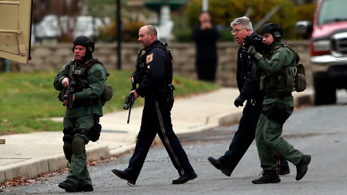 Police move near a home where a suspect is believed to have barricaded himself inside after shootings at multiple homes Monday, Dec. 15, 2014, in Souderton, Pa. Police tell WPVI-TV the man is suspected of killing a five people Monday morning at three different homes northwest of Philadelphia. (AP Photo/Matt Rourke)