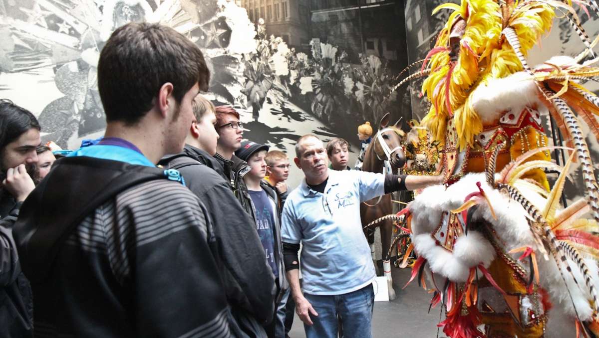  Students from the Arapahoe High School band learn about the cost of ostrich feathers at Philadelphia's Mummers Museum on Monday. (Kimberly Paynter/WHYY) 