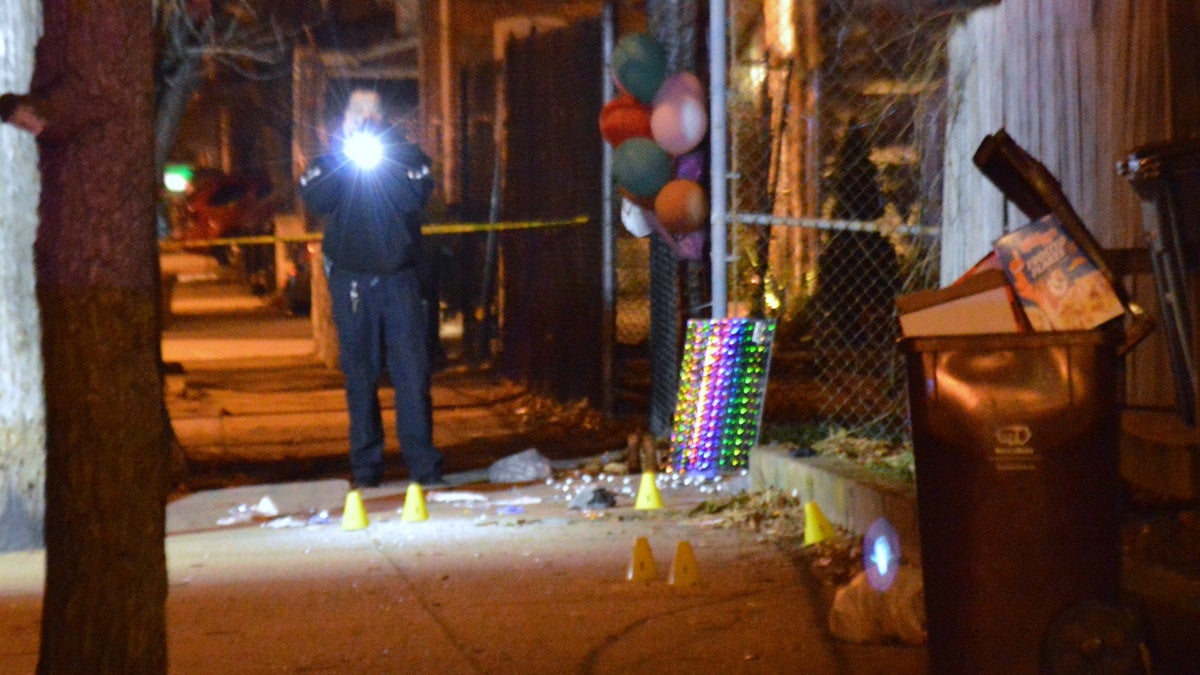 Balloons form a memorial to a shooting victim from Friday night as police mark evidence of Monday night's killing on the sidewalk. (John Jankowski/for NewsWorks)