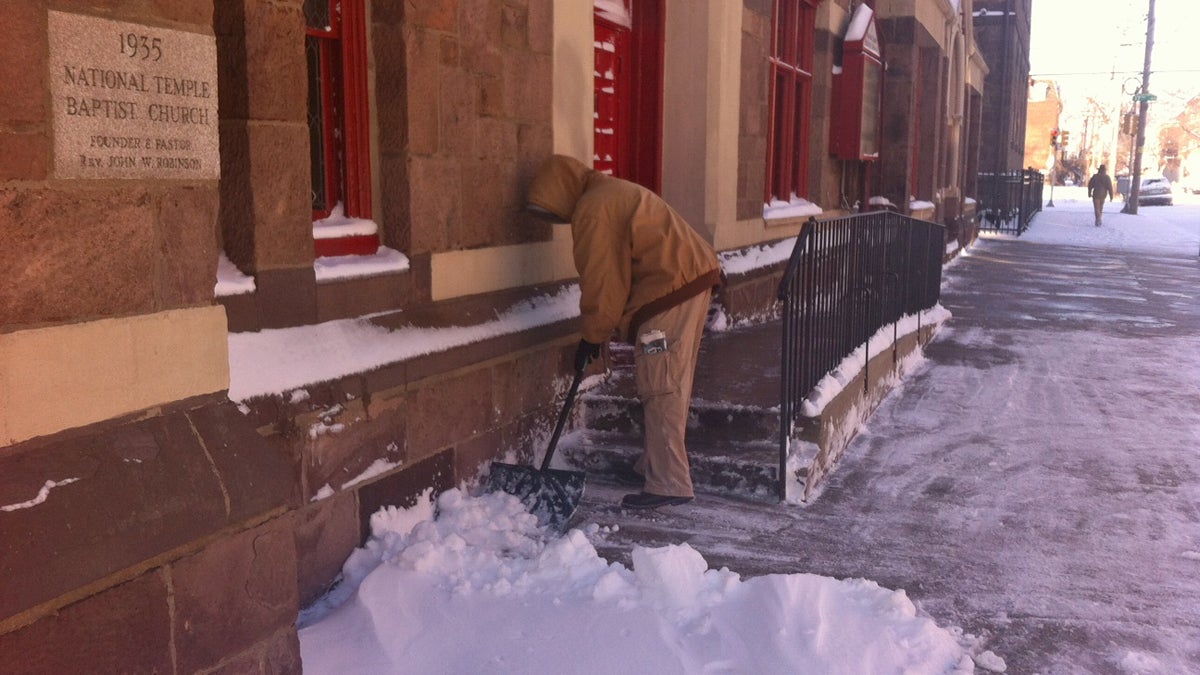  Deacon Brian Jarmon shovels in front of National Temple Baptist Church in North Philadelphia.  (Elizabeth Fiedler/WHYY)  