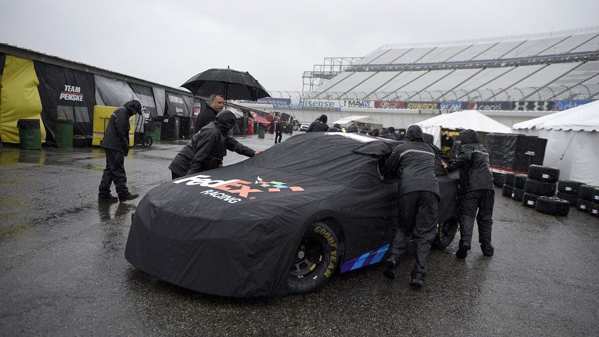 nascar-169 Crew members push the race car of Denny Hamlin in the garage area for the NASCAR Sprint Cup series auto race, Friday, Oct. 2, 2015, at Dover International Speedway in Dover, Del. (AP Photo/Nick Wass)