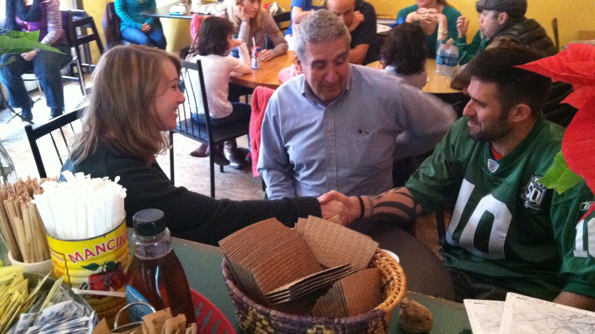 Caroline Picher recently helped father and son Dan (left) and Bryan Kennedy sign up for health insurance inside a coffee shop in Media