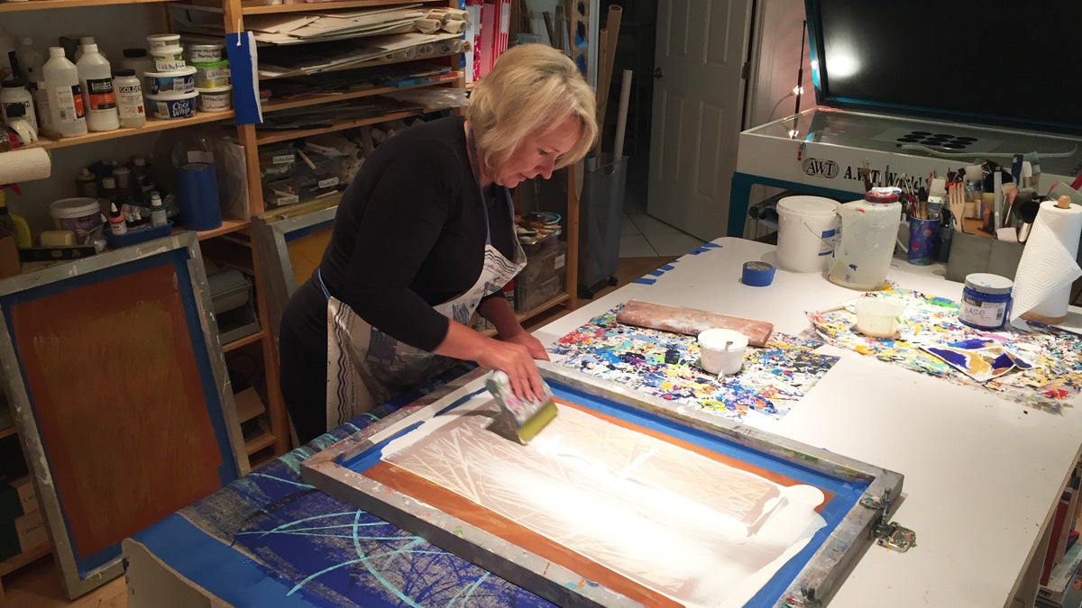 Nina Mickelsen works on a silk screen printing in her Lewes studio. (Brian Drouin/WHYY)