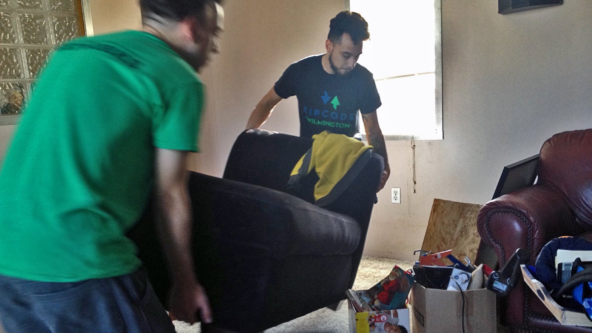  Joel Guevara (right) moves a chaise longue into his new apartment. (Avi Wolfman-Arent/WHYY) 