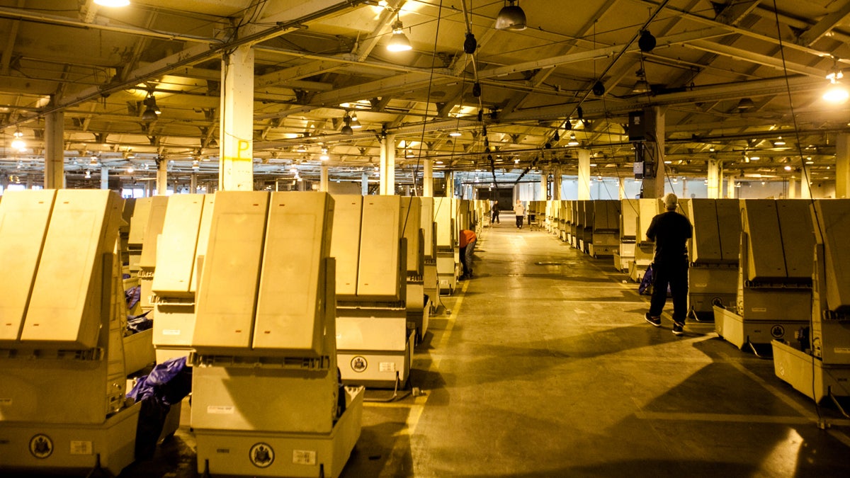 Workers prepare voting machines at the Office of the  City Commissioner's warehouse the day before the recount of votes in 75 precincts was set to begin. (Brad Larrison for NewsWorks)