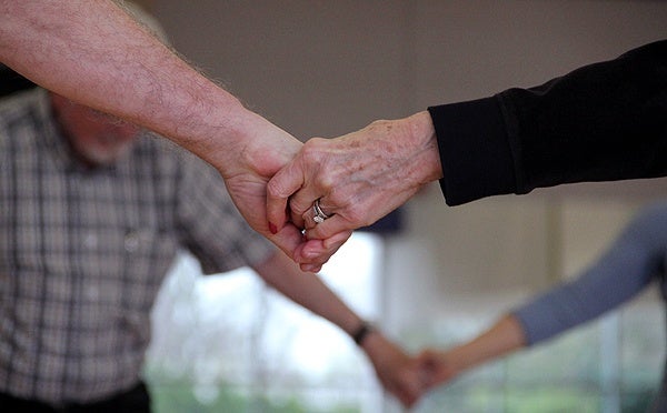  Dan and Connie MacNeil hold hands during a dance class for those with Parkinson's at the Abington YMCA. (Emma Lee/WHYY) 