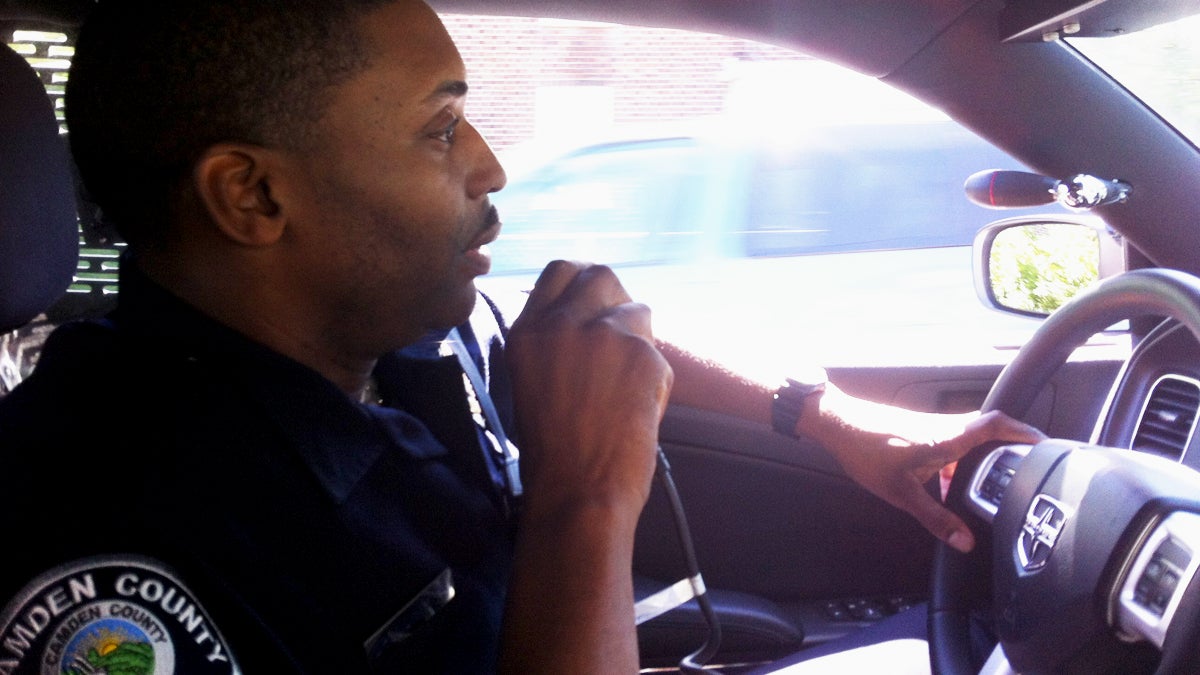  A Camden County police officer on the radio in a squad car. (NewsWorks file photo) 