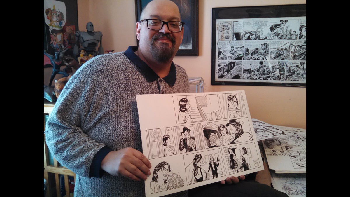 Upper Darby resident Mike Manley holds one of his illustrations for the Judge Parker serial comic strip. He also draws for Marvel and DC Comics and paints in a narrative-realist style. (Kimberly Haas/WHYY)