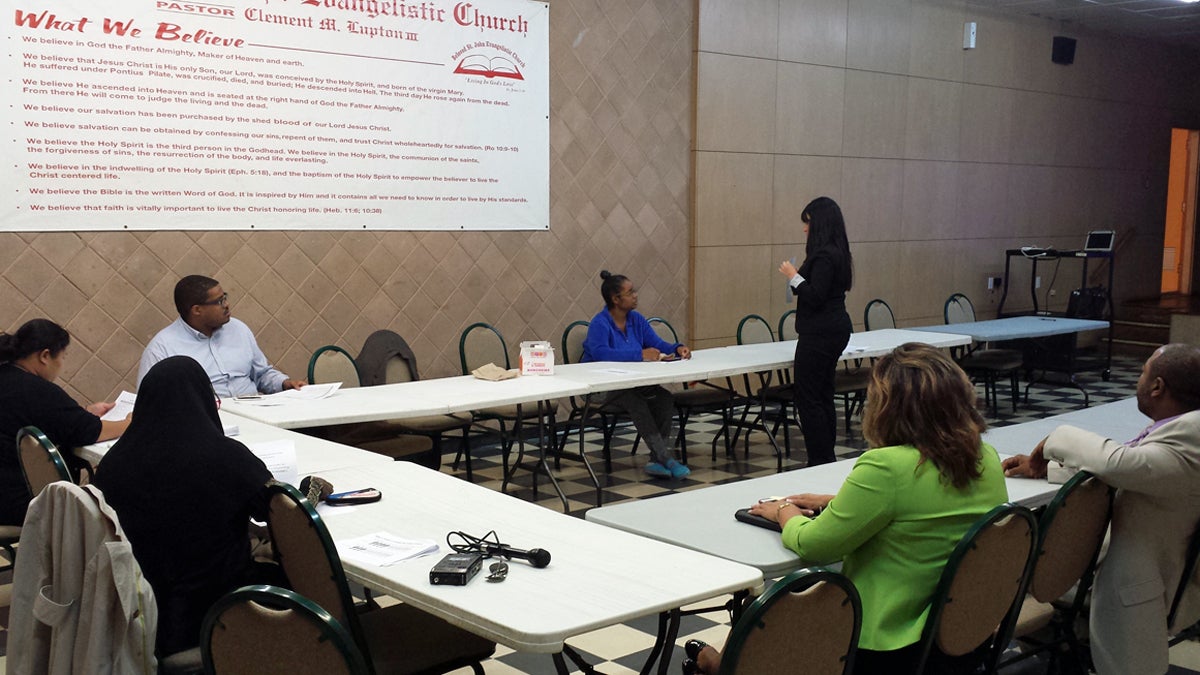  District staffers look on as assistant superintendent Randi Davila begins her presentation to the one Cooke parent present at the beginning of the meeting. At its peak, attendance reached about a dozen Cooke parents. (Kevin McCorry/WHYY) 