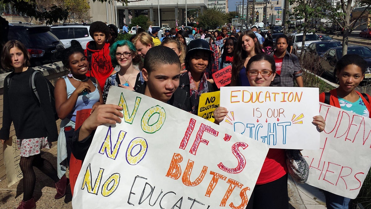  CAPA ninth-grader Jonah Rose ('No If's'), CAPA senior Elizabeth Gargiullo  (Education is our right), and ninth-grader Sophia Wharton (yellow sign) protest the resource deficiencies in Philadelphia schools. (Kevin McCorry/WHYY) 