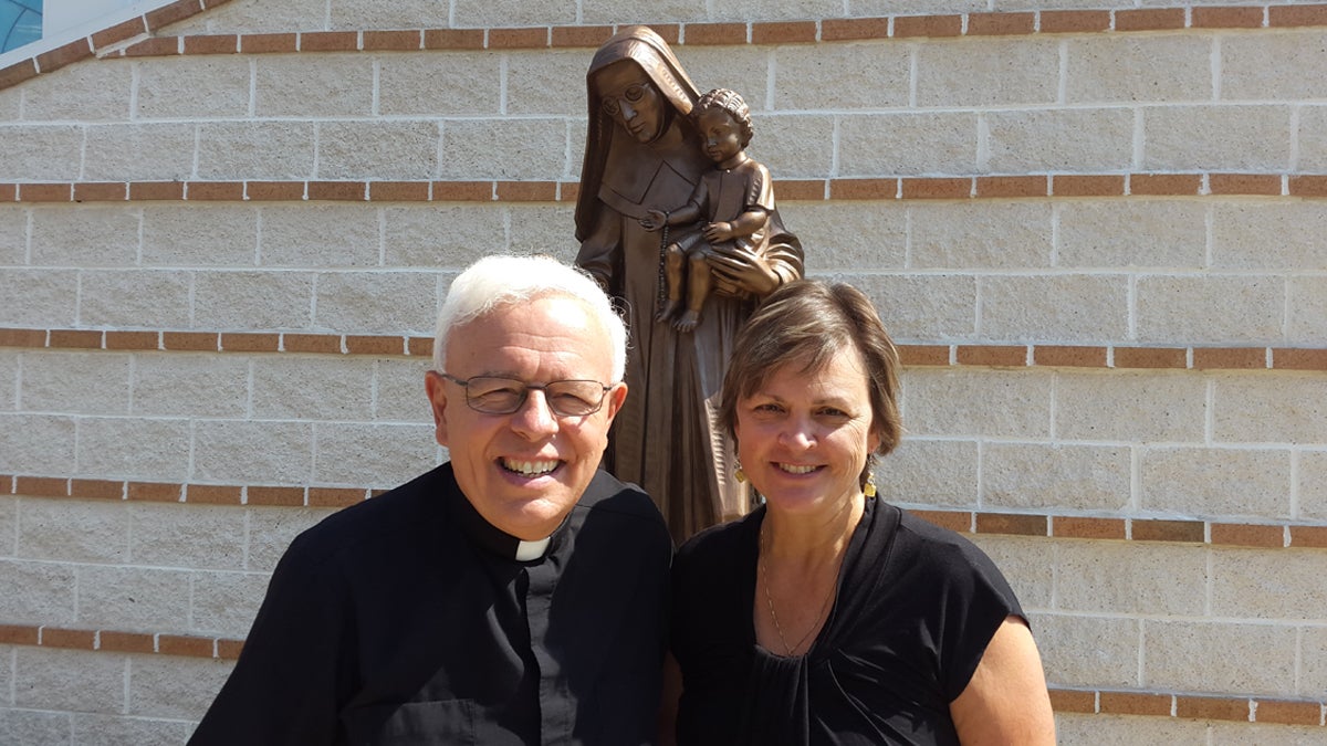  Monsignor John Marine and parishioner Kathy Nachtman stand in front of a statue of St. Katharine Drexel outside of St. Bede's parish. (Laura Benshoff/WHYY) 