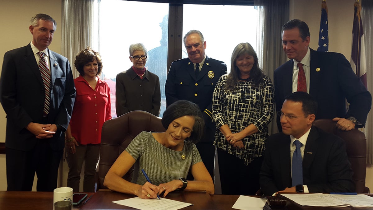  Montgomery County Commissioner Val Arkoosh signs the standing order to allow pharmacies to dispense naloxone without a prescription. (Laura Benshoff/WHYY) 