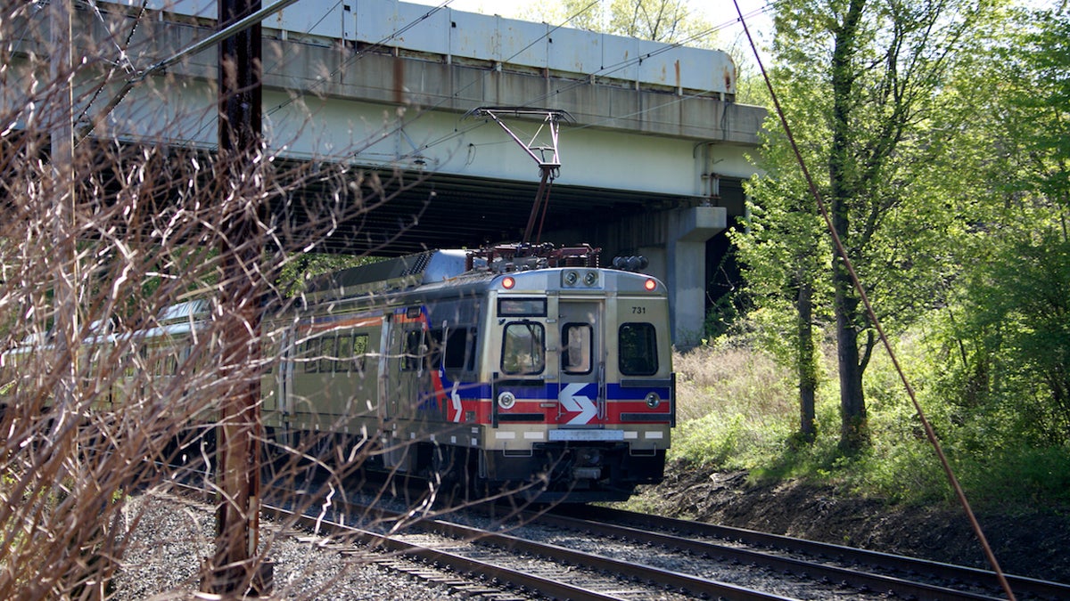 A SEPTA Regional Rail train passes under a bridge.  