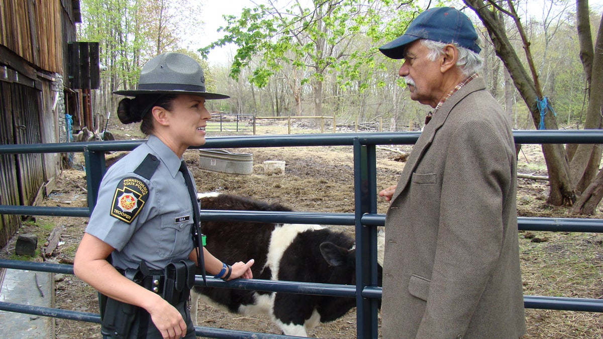 Dr. Shankar Shastri (right) talks with Pa. State Trooper Carie Gula after the people who dumped a severed cow head at his bovine sanctuary were charged. (Ramaa Reddy Raghavan/for NewsWorks)