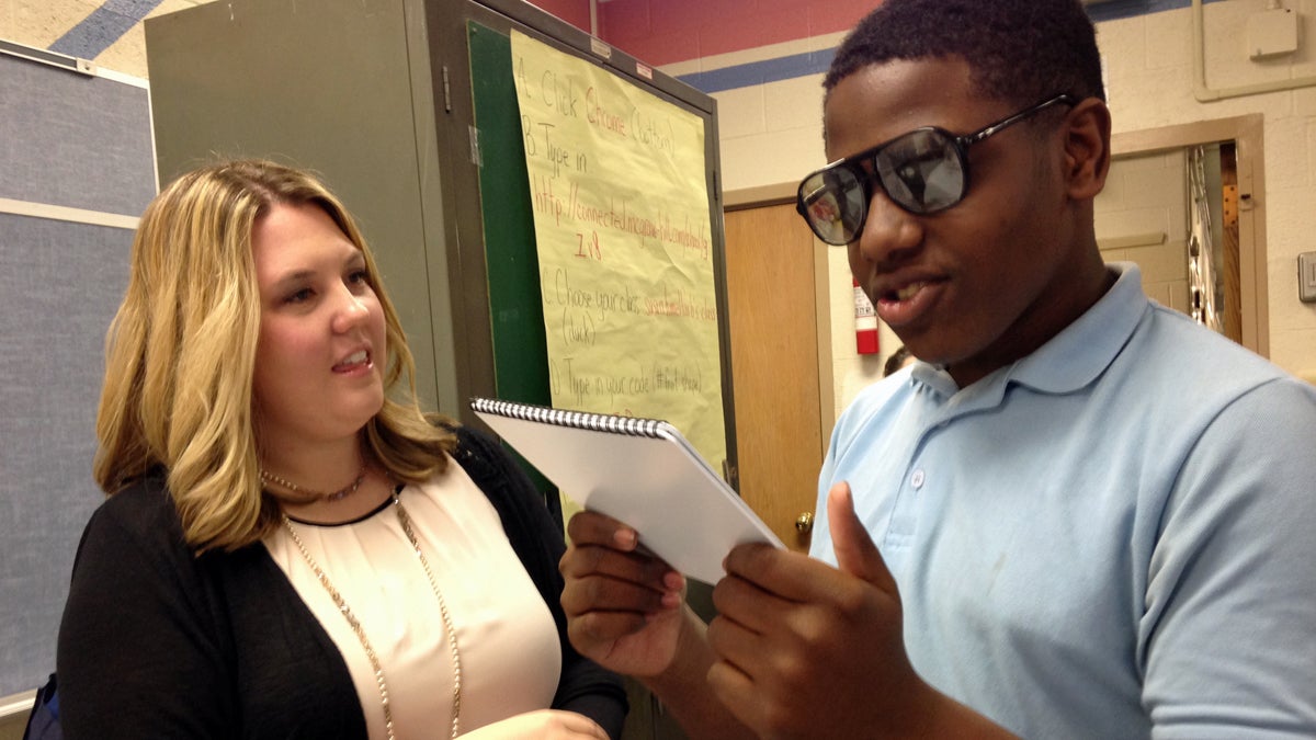  Meghan Mattson shows a seventh-grader at Alexander Adaire School in Fishtown vision-impairing glasses that simulate post-concussion symptoms.(Todd Bookman/WHYY) 