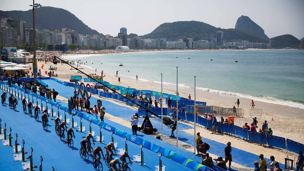 Competitors ride through the transition area during the men's triathlon event along Copacabana beach at the 2016 Summer Olympics in Rio de Janeiro