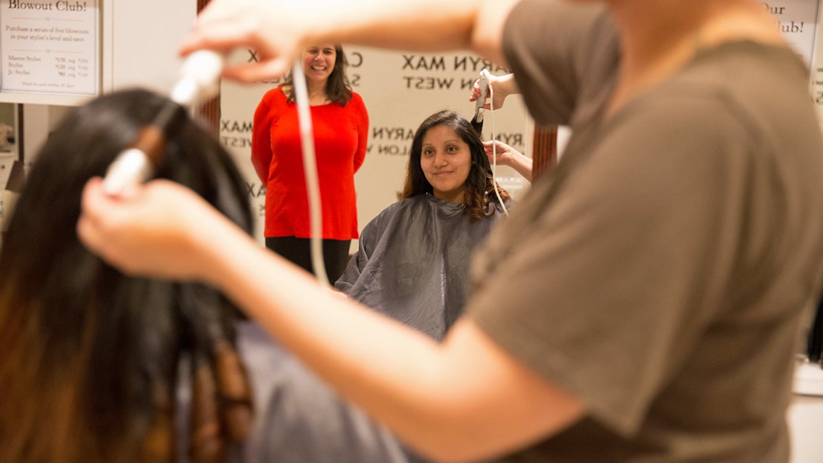  Kellie Harrison curls and styles Leticia Montiel's hair as part of the Salvation Army's Operation Cinderella night.  It's been a year since she has had her hair done, said Montiel.  (Lindsay Lazarski/WHYY) 