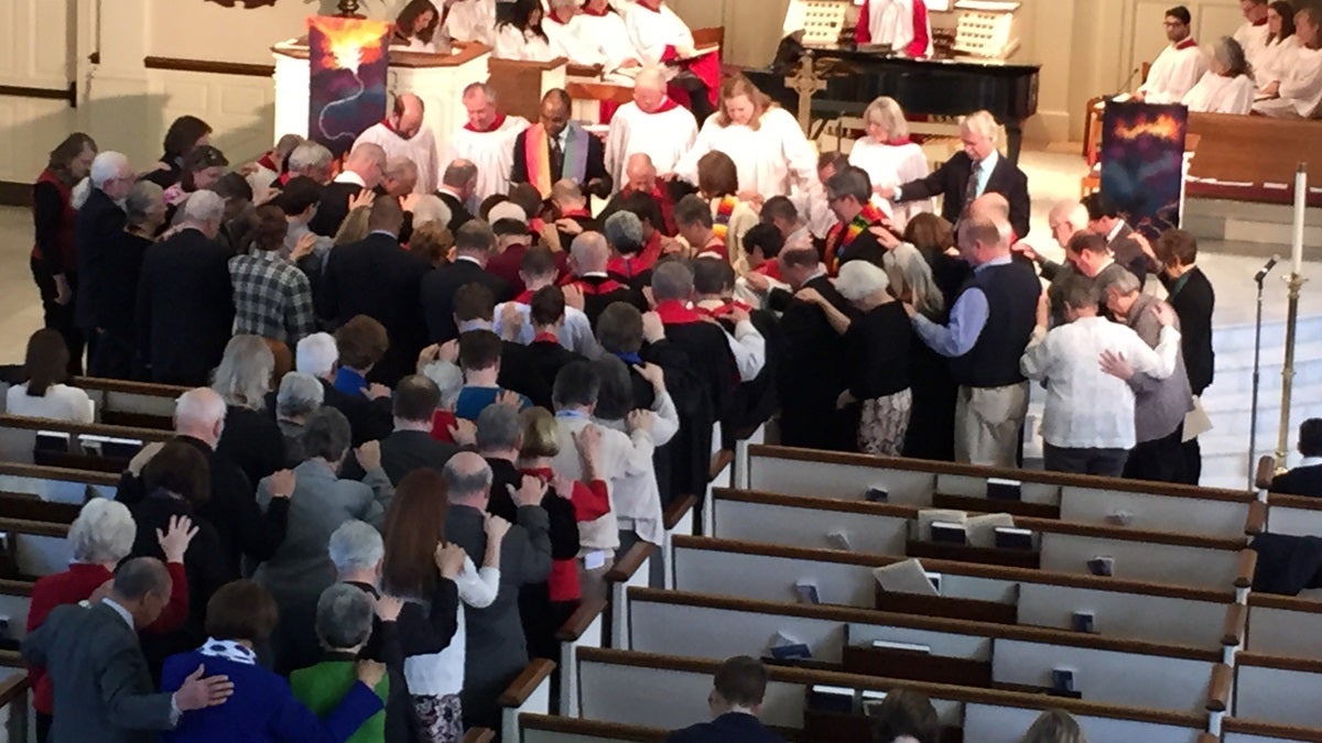  Church leaders lay hands on Kaci and Holly Clark Porter during an ordination service Sunday afternoon in Wilmington. (Paul Parmelee/WHYY) 