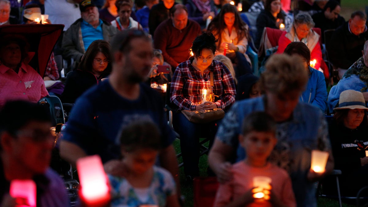  People bow their heads in prayer during a prayer vigil Saturday, Oct. 3, 2015, in Winston, Ore. The vigil was held in honor of the victims of the fatal shooting at Umpqua Community College on Thursday. (AP Photo/John Locher) 