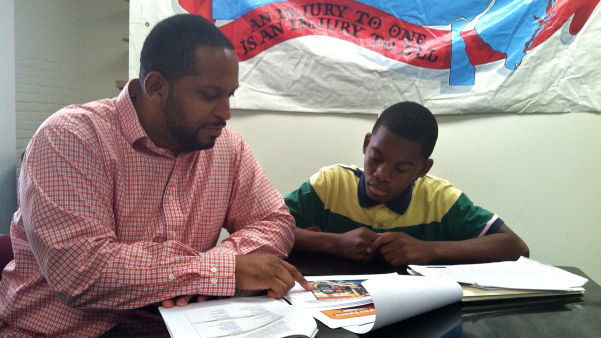  Damon Walker (left), a trainer with Philadelphia Area Project on Occupational Safety and Health, and his son, 14-year-old Wendell Skinner, a peer educator, prepare for a new program to help teens address and avoid workplace violence. (Elana Gordon/WHYY) 