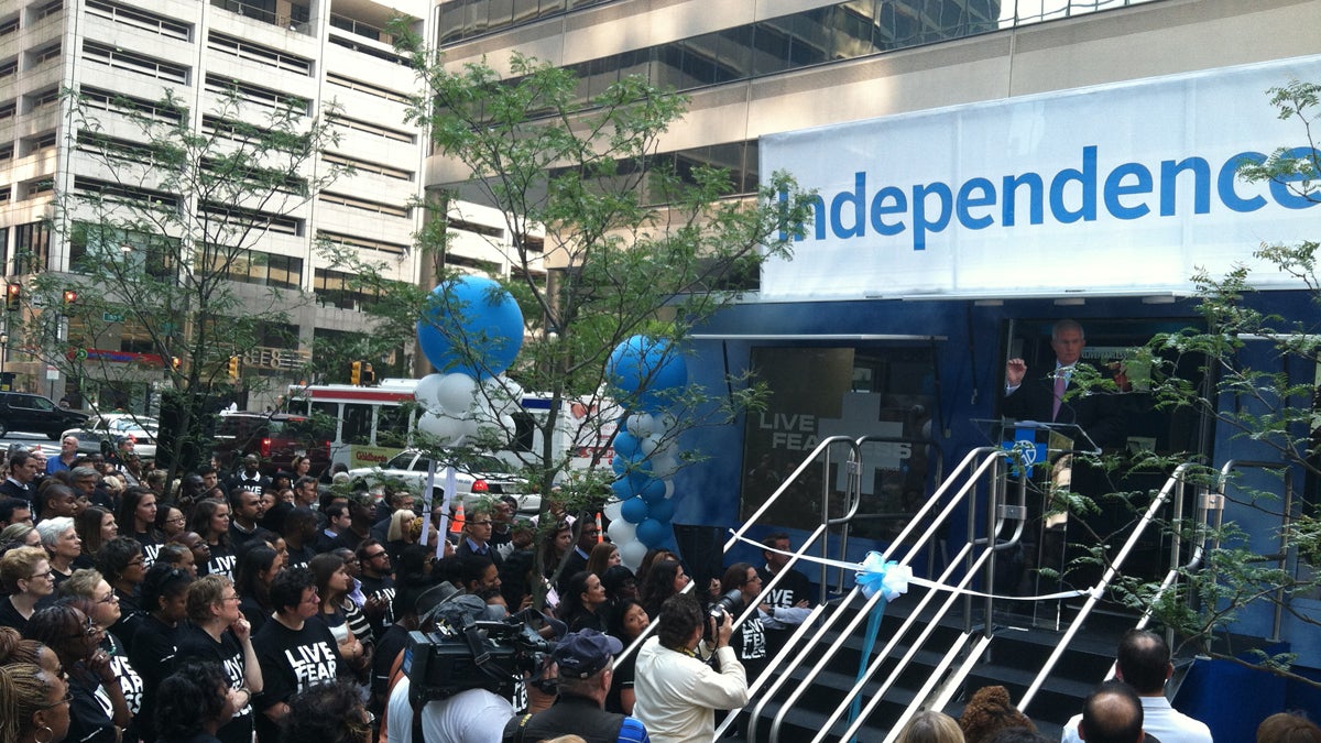  Employees and executives of Independence Blue Cross crowd around a new outreach truck parked outside the company's headquarters. (Elana Gordon/WHYY) 