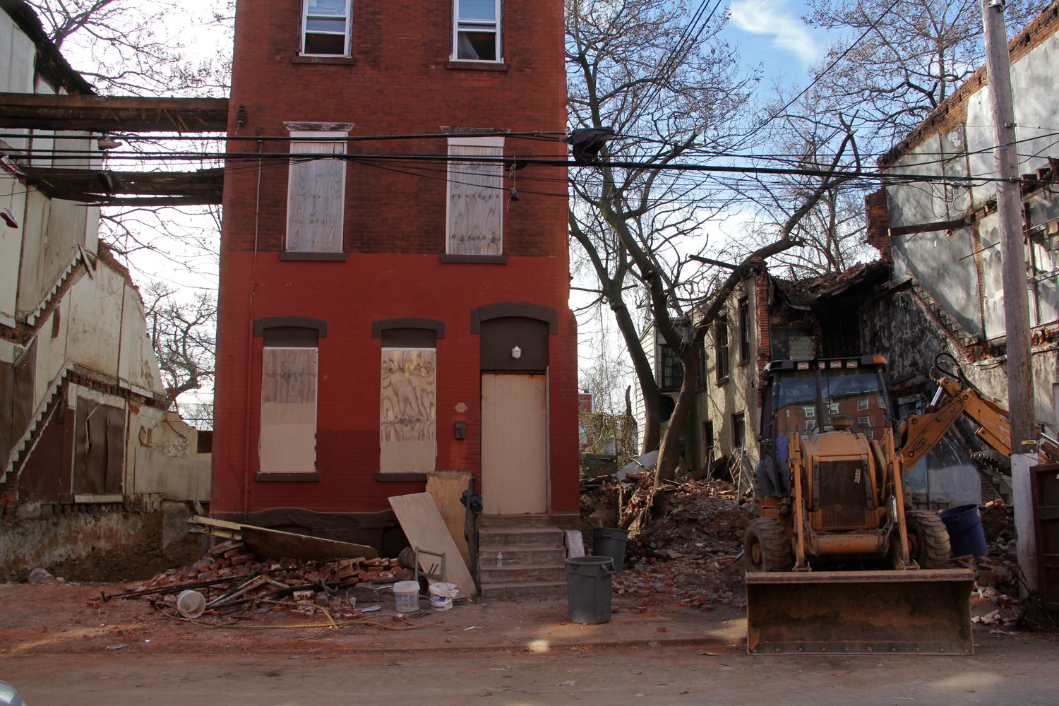 A home is demolished in the Sharswood section of North Philadelphia. (Emma Lee/WHYY)