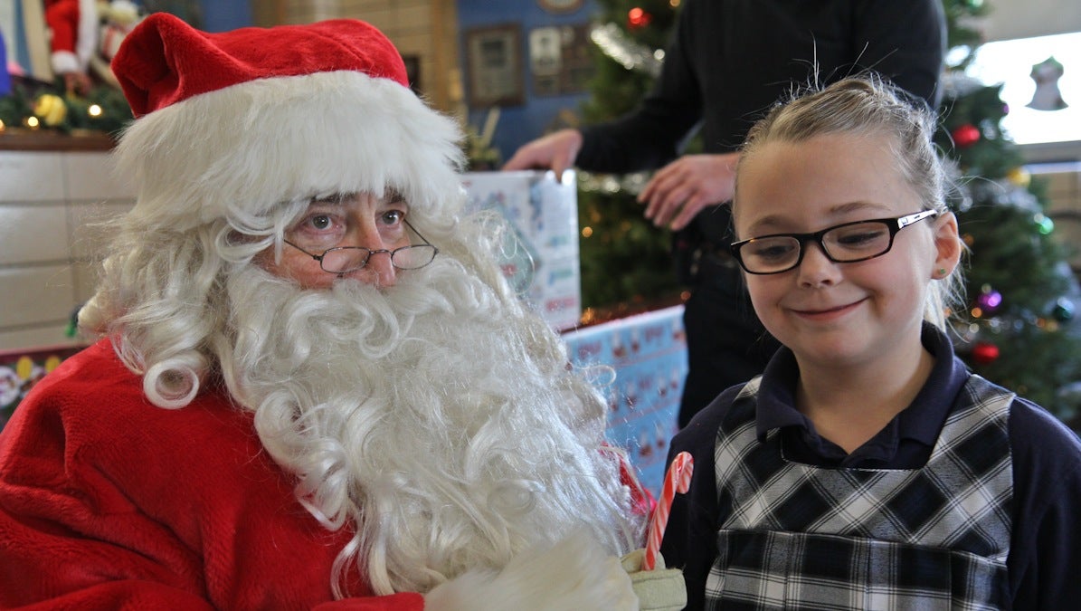 Riley Fitzpatrick asks Santa for a puppy at the 5th District Police Station Annual Christmas party. (Kimberly Paynter/WHYY)