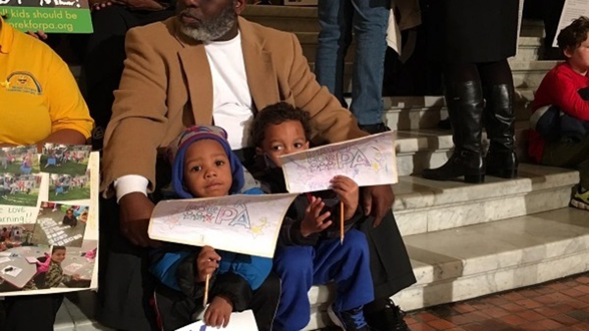  Pastor Scott Barkley, with the Bright Futures Learning Center in Harrisburg, sits with two of its 3-year-old students, Justice and Cortez, at the state Capitol. (Mary Wilson/WITF)  