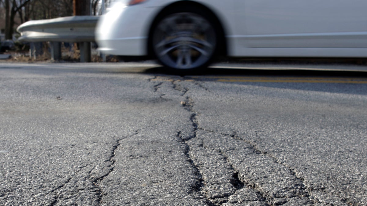  A car drives over crumbling pavement in Carlisle, Pa.  (AP File Photo/Carolyn Kaster) 