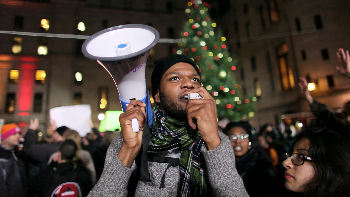  A protester uses a bullhorn during a demonstration on Wednesday Dec. 3, 2014, at a tree lighting ceremony in Philadelphia. The crowd protests the deaths of two unarmed black men at the hands of police. (AP Photo/ Joseph Kaczmarek) 