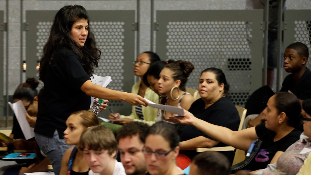  In this Aug. 29, 2013 photo, principal Debora Borges-Carrera hands out information packets to students and parents during an open house for incoming freshman and transfer students at Kensington High School for the Creative and Performing Arts in Philadelphia. (AP Photo/Matt Slocum) 