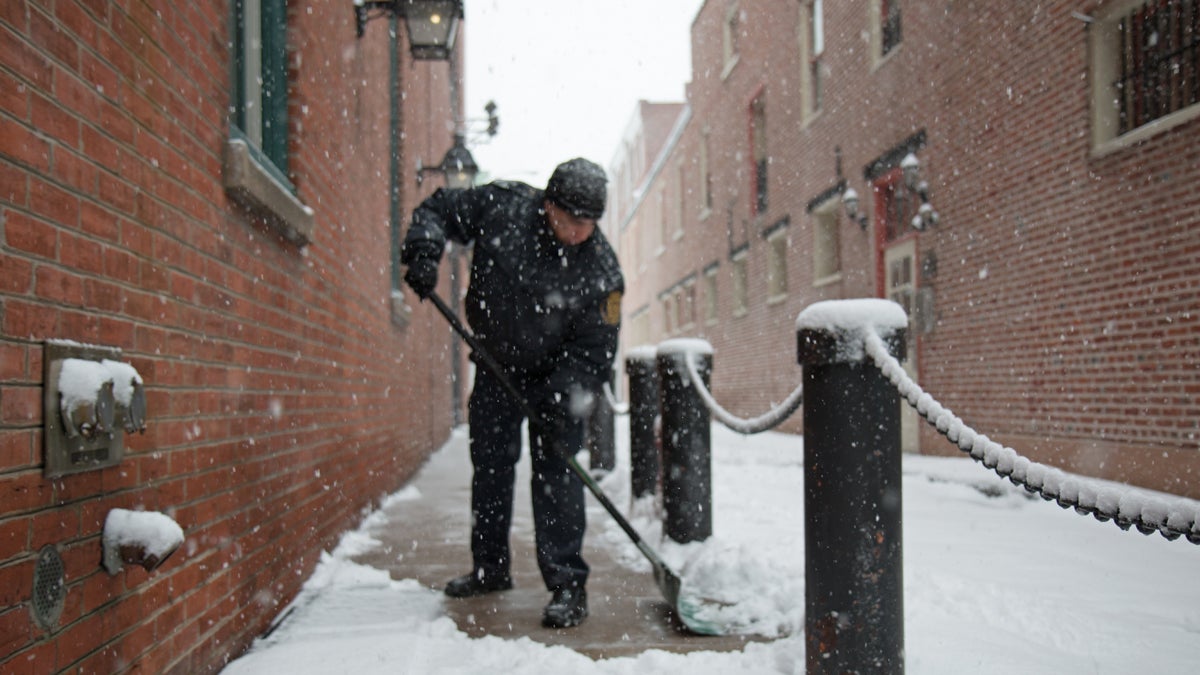  Wintry weather blankets the Philadelphia region. Firefighter Alberto Gonzalez shovels the sidewalk outside of the Fireman’s Hall Museum in Old City. (Lindsay Lazarski/WHYY) 