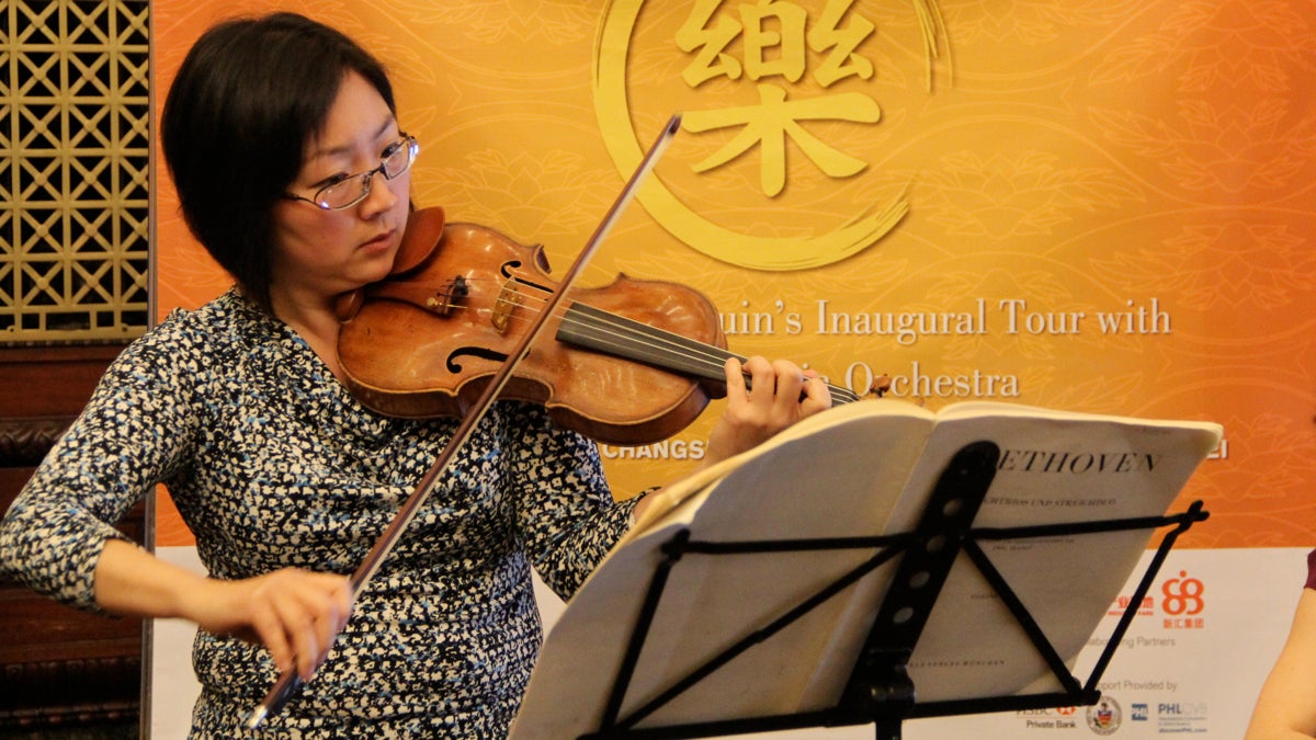  Philadelphia Orchestra's Juliette Kang plays at a press conference at City Hall to announce the orchestra's tour of China. (Emma Lee/WHYY) 