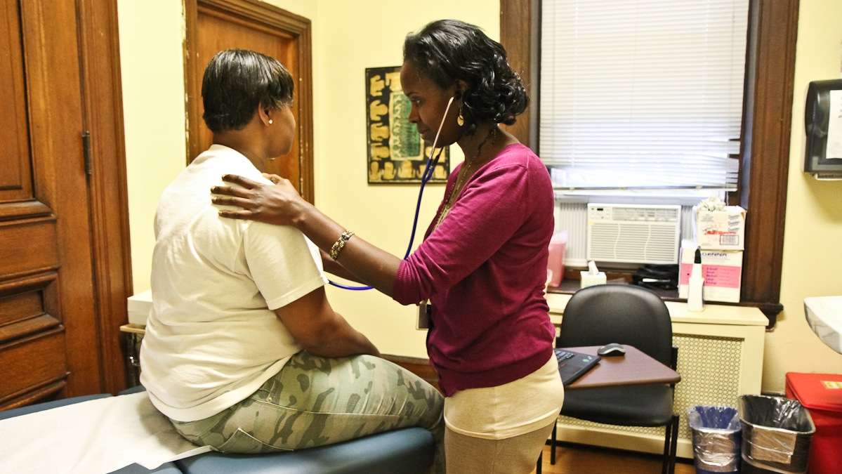 Lucy Kibe examines patient Sherri Robinson at St. Elizabeth Wellness Center