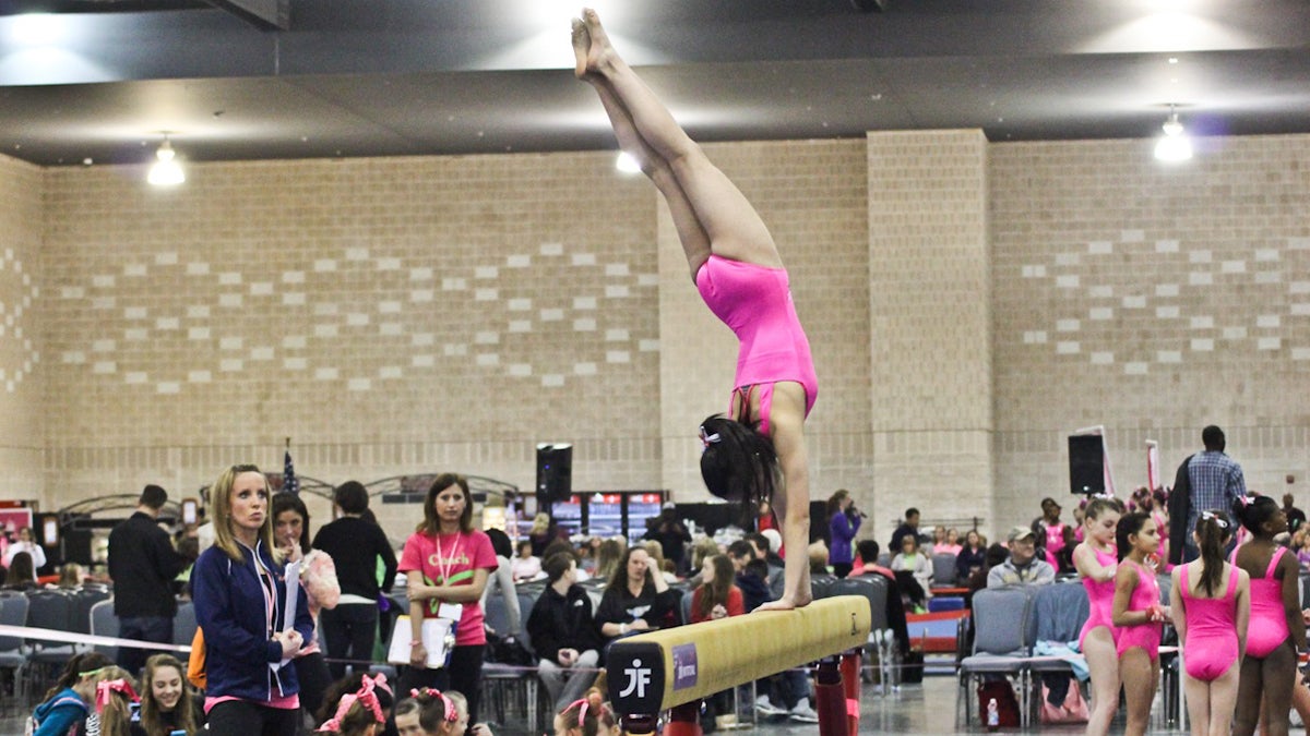  Ingrid Shu, 12, dismounts the balance beam at the sixth annual Pink Invitational tournament in Philadelphia. (Kimberly Paynter/WHYY) 
