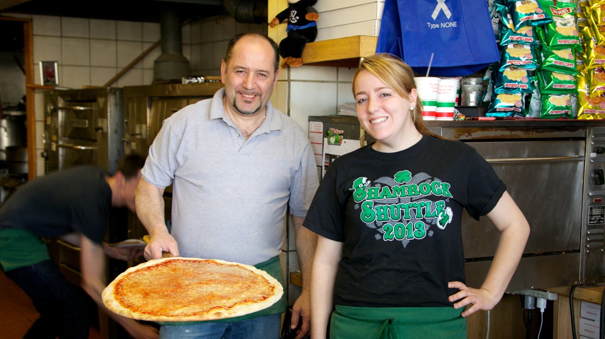  Nunzio Esimeo shows off a fresh cheese pizza, with Danielle Lagomarisno at Montesini Pizza (Nathaniel Hamilton/for NewsWorks) 