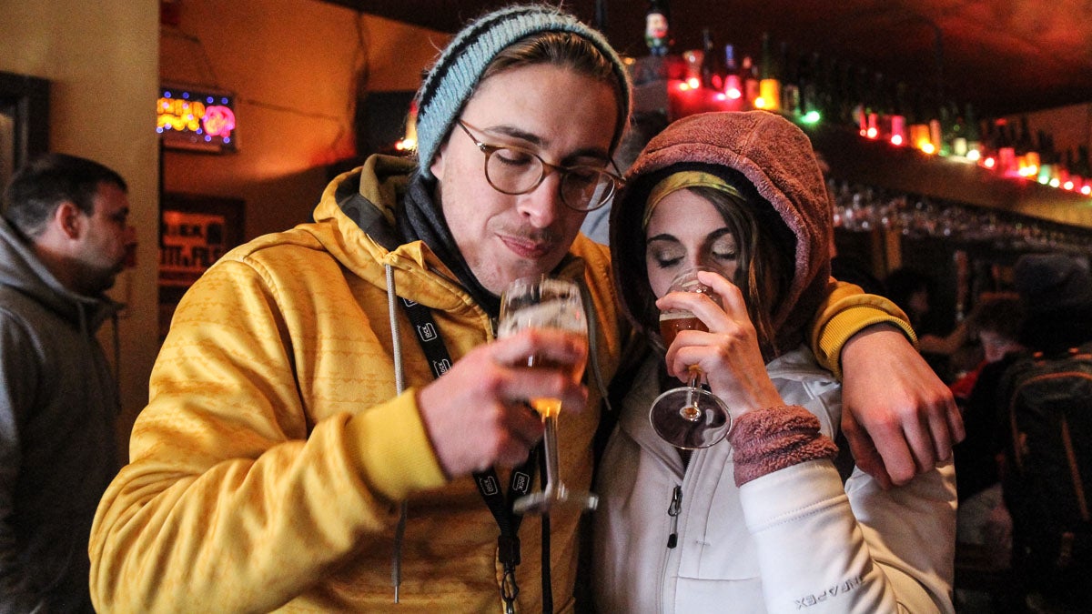 Andrew Wummer and his girlfriend Christina Forysthe enjoy their Russian River Pliny the Younger Triple IPAs at Monk's Cafe Monday. (Kimberly Paynter/WHYY)