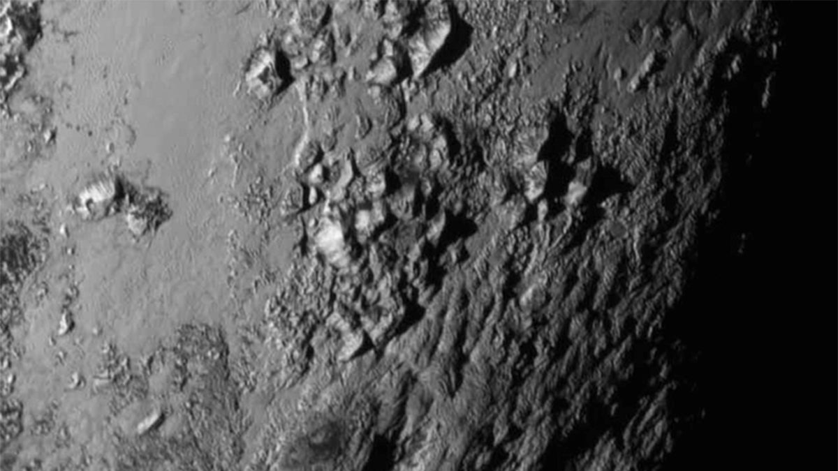 This image provided by NASA on Wednesday shows a region near Pluto's equator with a range of mountains captured by the New Horizons spacecraft. (NASA/JHUAPL/SwRI via AP)
